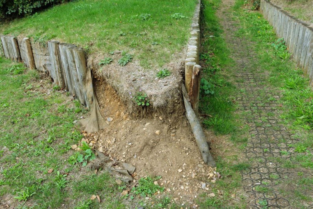Retaining wall leaning outward with water damage in a clay-heavy St. Louis yard