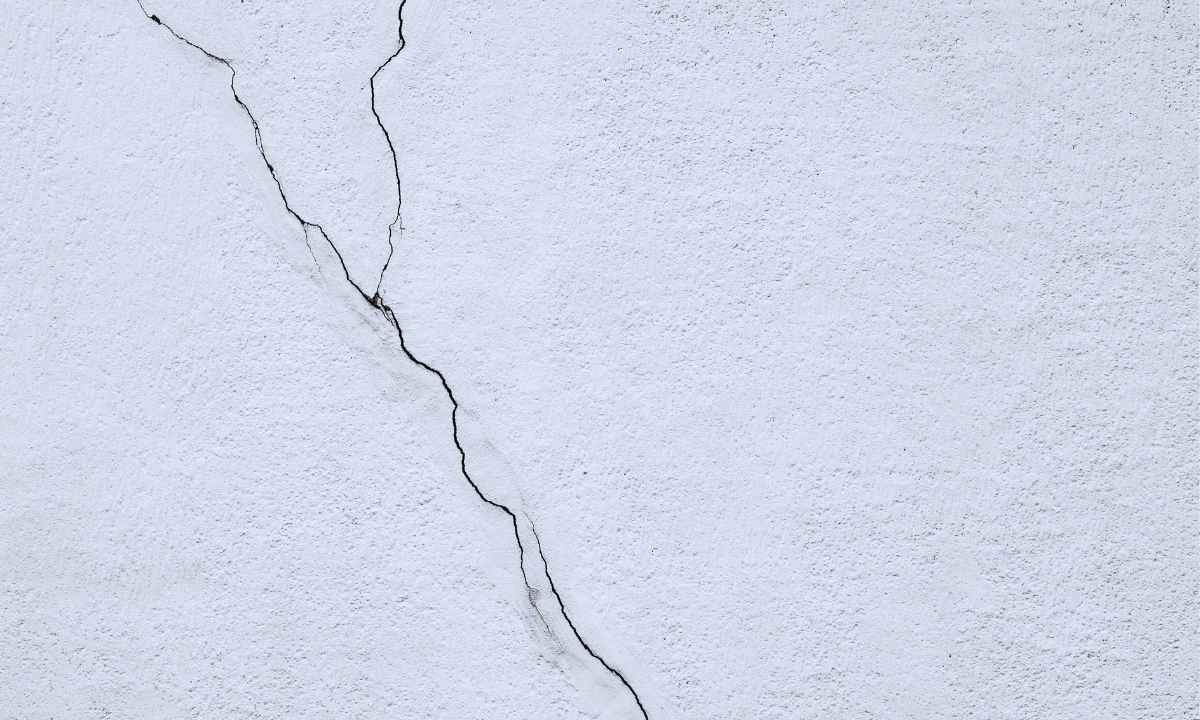 Deep crack in light concrete wall caused by soil movement in St. Louis, Missouri — shows structural stress from clay expansion and freeze-thaw cycles"