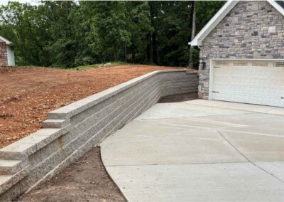 Completed retaining wall and driveway by Retaining Wall & Paving Solutions during fall construction season in St. Louis residential property.