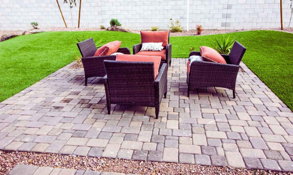 Backyard patio featuring a seating area on interlocking concrete pavers, demonstrating a stable and level surface ideal for cold-weather climates.