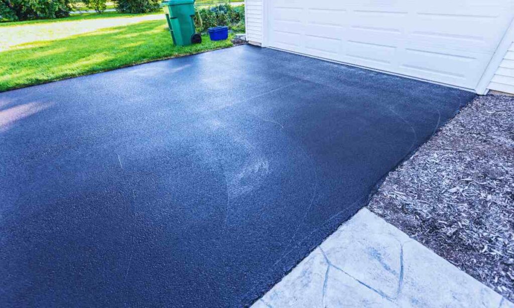Freshly resurfaced residential driveway with smooth, uncracked asphalt—an example of proper preparation over expansive clay soil in St. Louis to prevent future driveway damage.