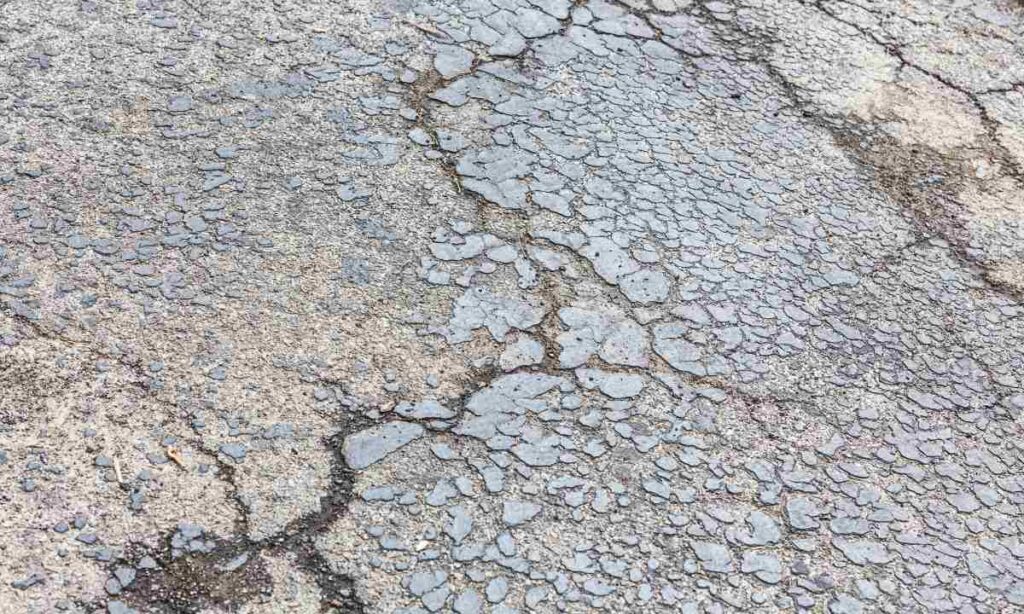 Damaged driveway pavement with extensive surface cracking and erosion, illustrating how St. Louis clay soil causes deterioration when left unaddressed.