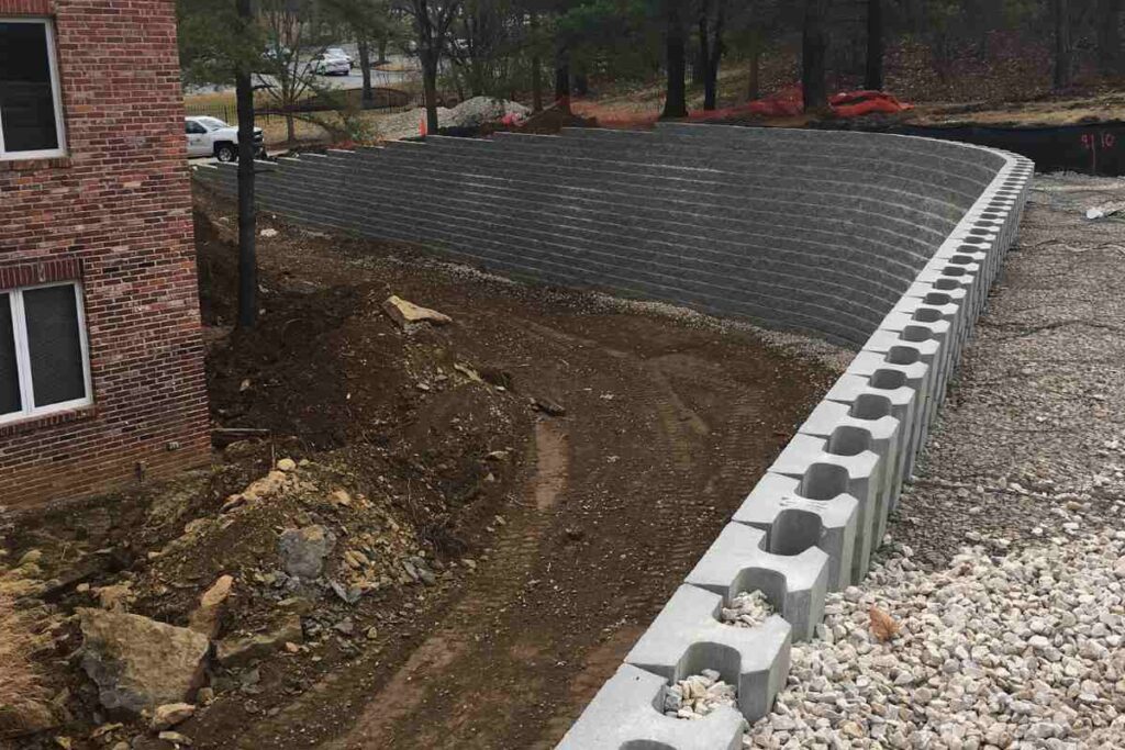 Segmental retaining wall under construction showing modular block facing, drainage gravel, and compacted backfill in Chesterfield, Missouri