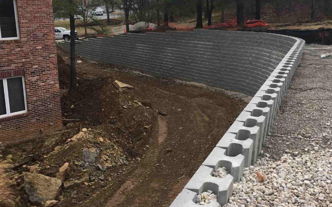 Segmental retaining wall under construction showing modular block facing, drainage gravel, and compacted backfill in Chesterfield, Missouri