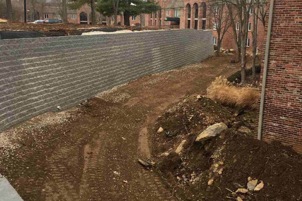 Completed retaining wall on steep residential lot showing grade change and usable yard space created where regrading was not viable